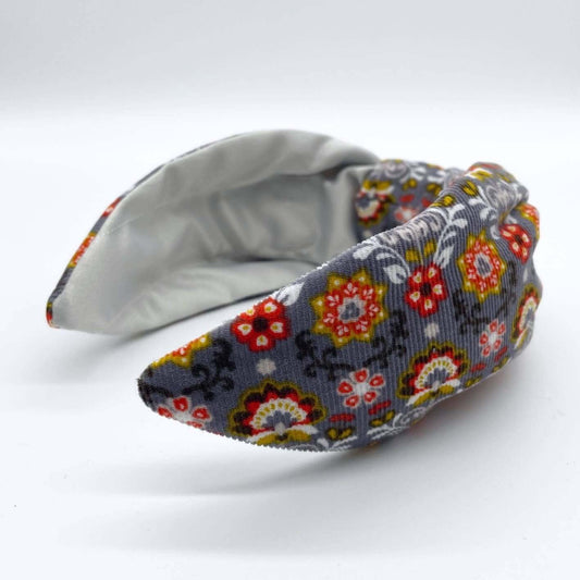 A bow-style, Scandinavian pale grey floral-print knot headband with an ice-white lining underneath.