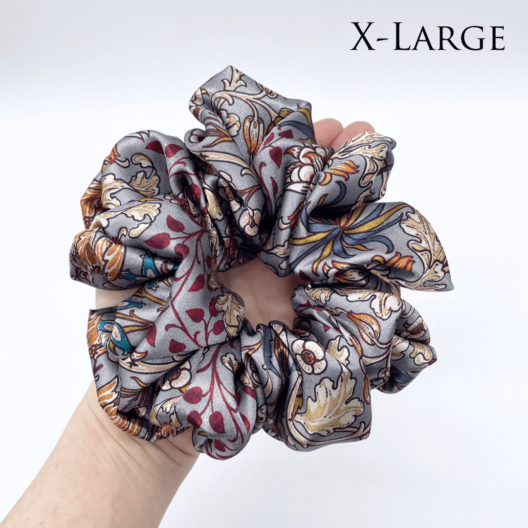One extra large satin scrunchie laying flat on a hand